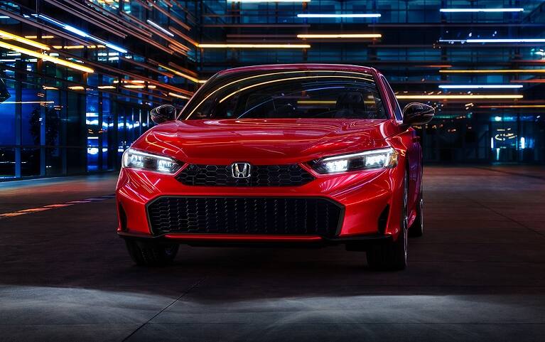 2027 Honda Civic Sedan Sport Touring Hybrid in Rallye Red front view with headlights on (Compact Sedan)